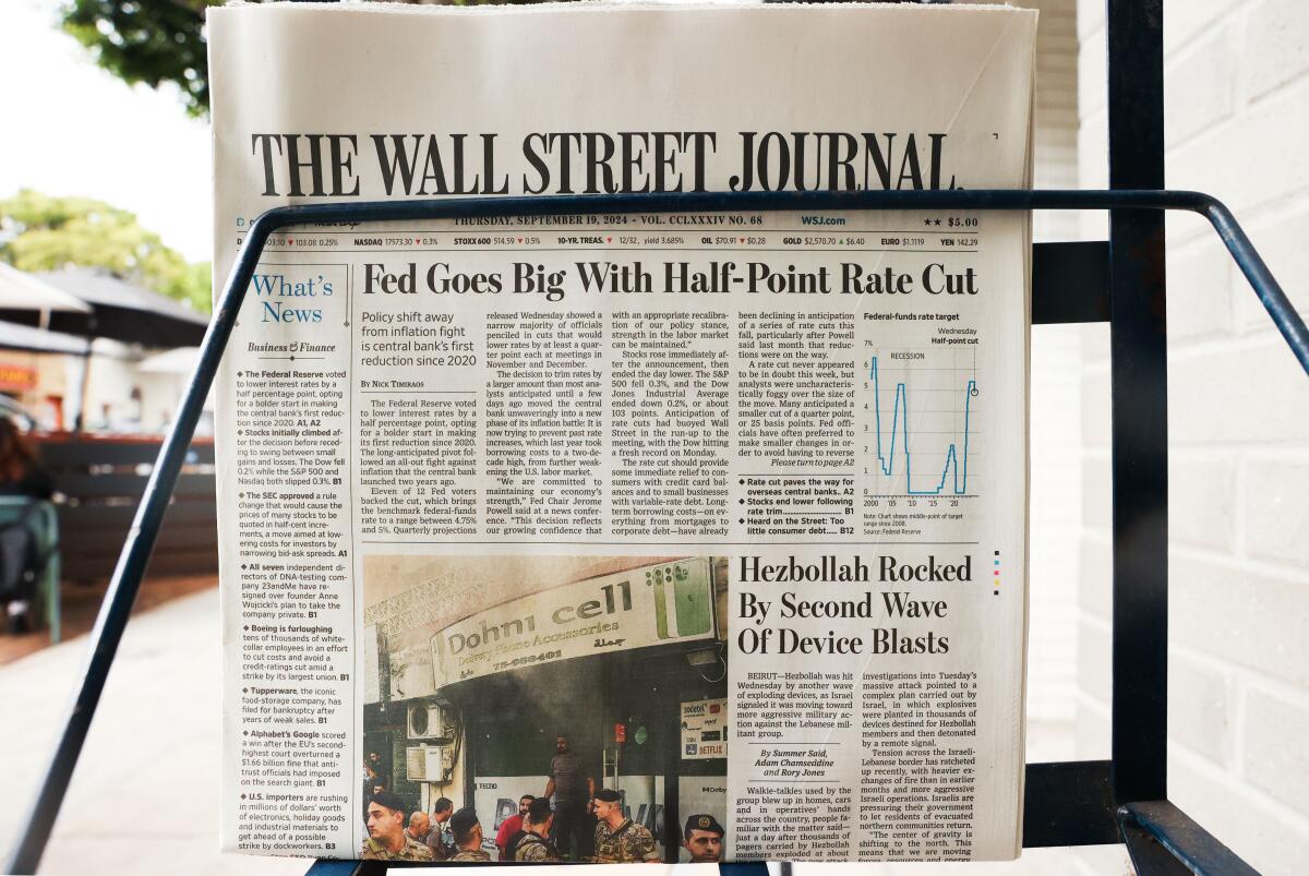 The front page of the Wall Street Journal for sale at a newsstand