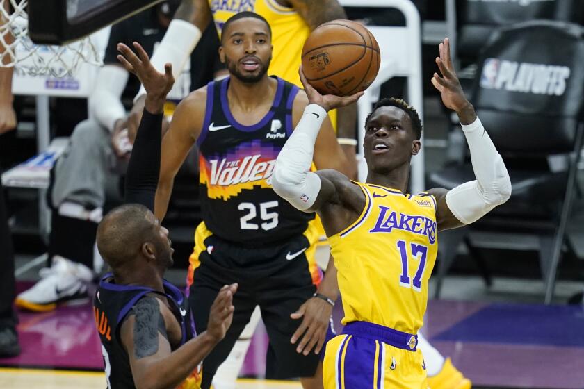 Los Angeles Lakers guard Dennis Schroder (17) gets off a shot over Phoenix Suns guard Chris Paul, left, as Suns forward Mikal Bridges (25) looks on during the first half of Game 2 of their NBA basketball first-round playoff series Tuesday, May 25, 2021, in Phoenix. (AP Photo/Ross D. Franklin)