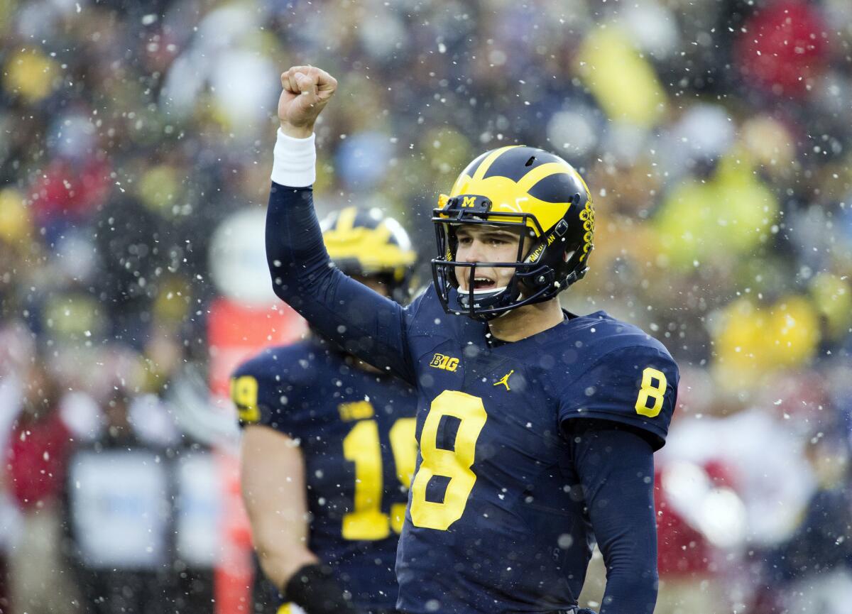 Michigan quarterback John O'Korn signals back to his sideline between downs in the first quarter on Nov. 19.