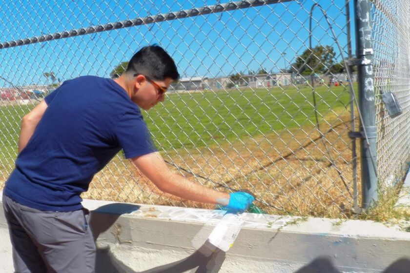 Rotaract member Erick Ramirez removing graffiti.