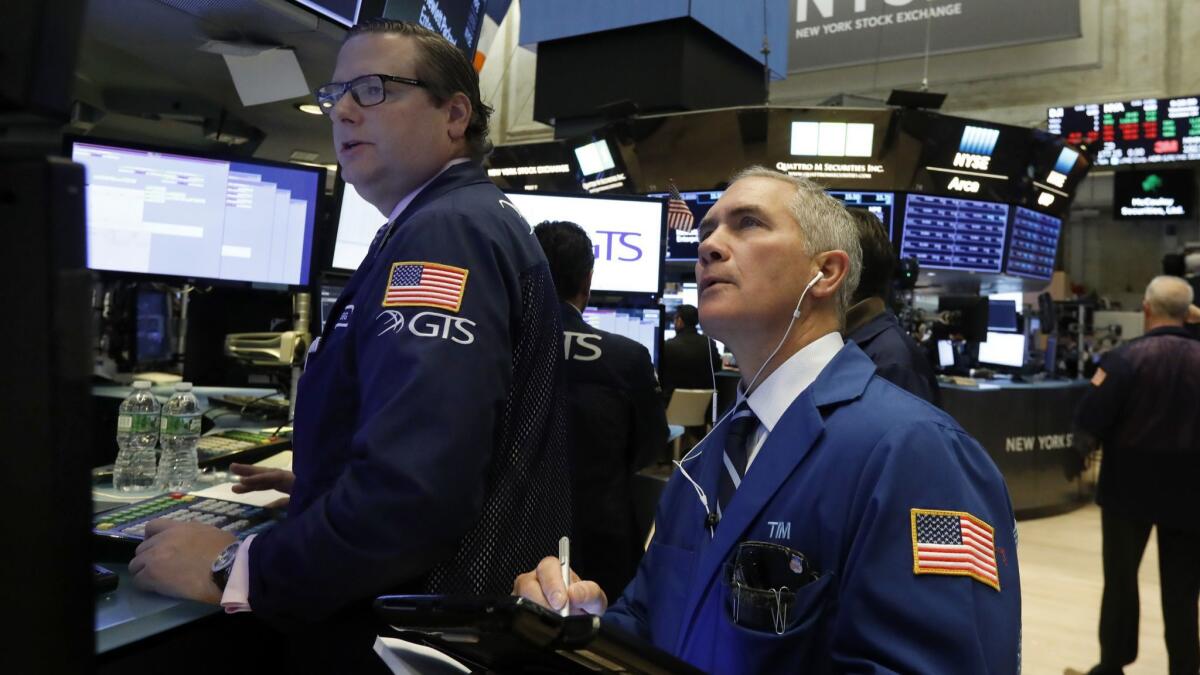 Specialist Gregg Maloney, left, and trader Timothy Nick work on the floor of the New York Stock Exchange in October.