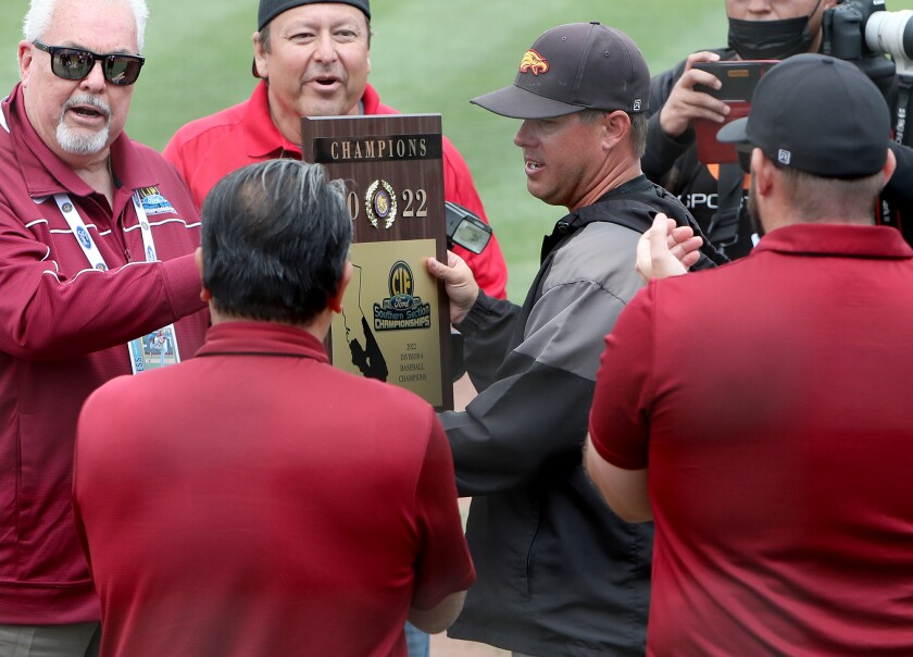 Estancia coach Nate Goellrich, center, accepts the championship plaque at Cal State Fullerton on Saturday.