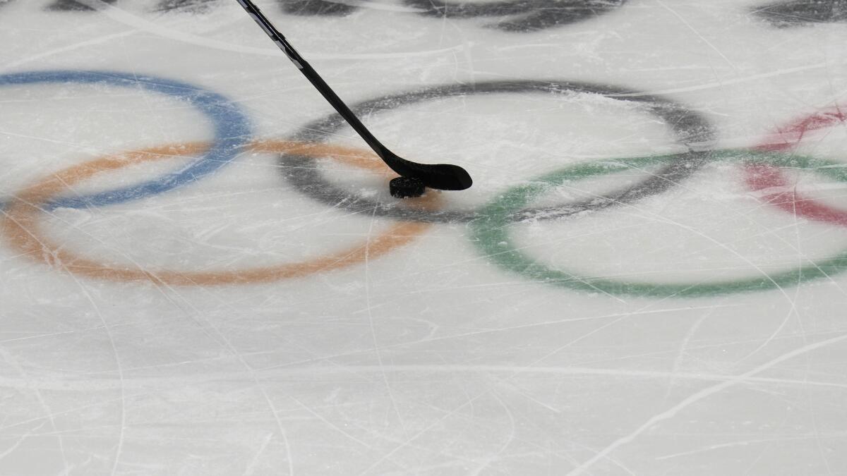 A puck slides over the Olympic rings during a hockey practice.