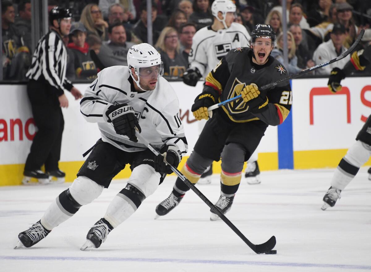 Kings captain Anze Kopitar controls the puck ahead of Vegas Golden Knights forward Nick Cousins during the Kings' 4-1 win Sunday.