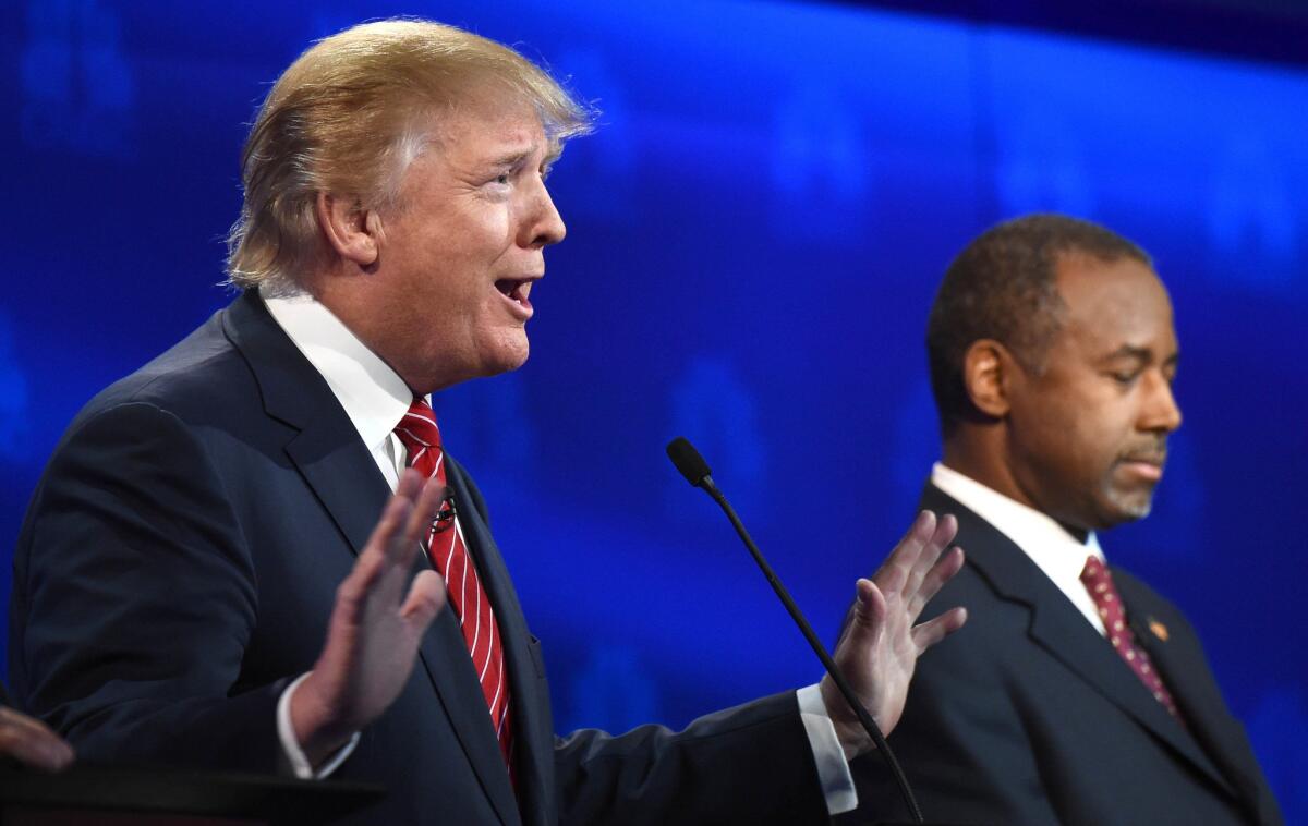 Republican presidential hopeful Donald Trump speaks as Ben Carson look on during the CNBC Republican Presidential Debate at the Coors Event Center at the University of Colorado in Boulder, Color.
