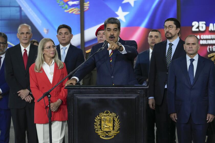 Venezuelan President Nicolas Maduro speaks to the press at the Supreme Court where he arrived for procedures related to the court's audit of presidential election results in Caracas, Venezuela, Friday, Aug. 9, 2024. Behind is an image of Independence hero Simon Bolivar. (AP Photo/Matías Delacroix)