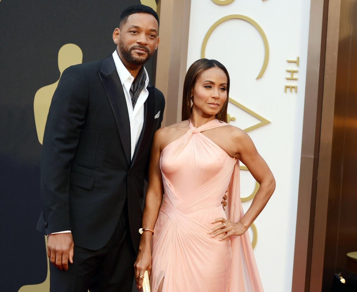 Will Smith, left, and Jada Pinkett Smith arrive at the Oscars ceremony in 2014.