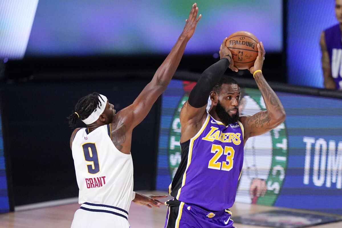 Lakers forward LeBron James looks to pass while defended by Nuggets forward Jerami Grant during Game 5.