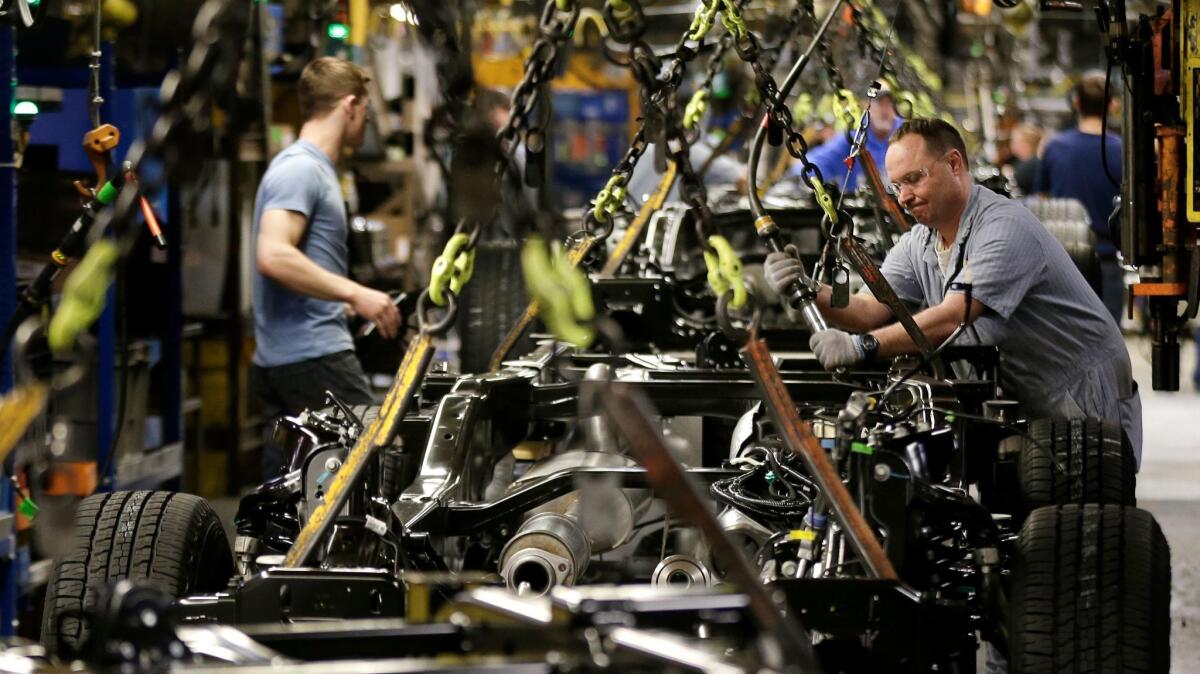 A worker prepares a chassis to receive an engine at Ford's Kansas City Assembly Plant in Claycomo, Mo.