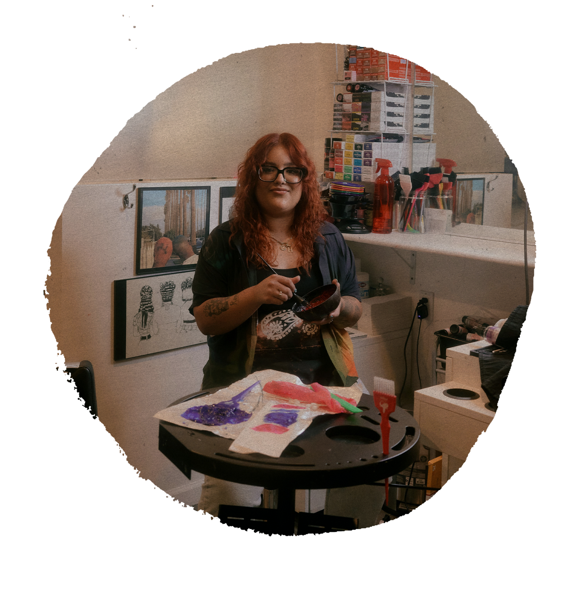 circular photo of hair artist Brenda Huerta (a.k.a. @c0mptonkitty) at her station mixing hair dye