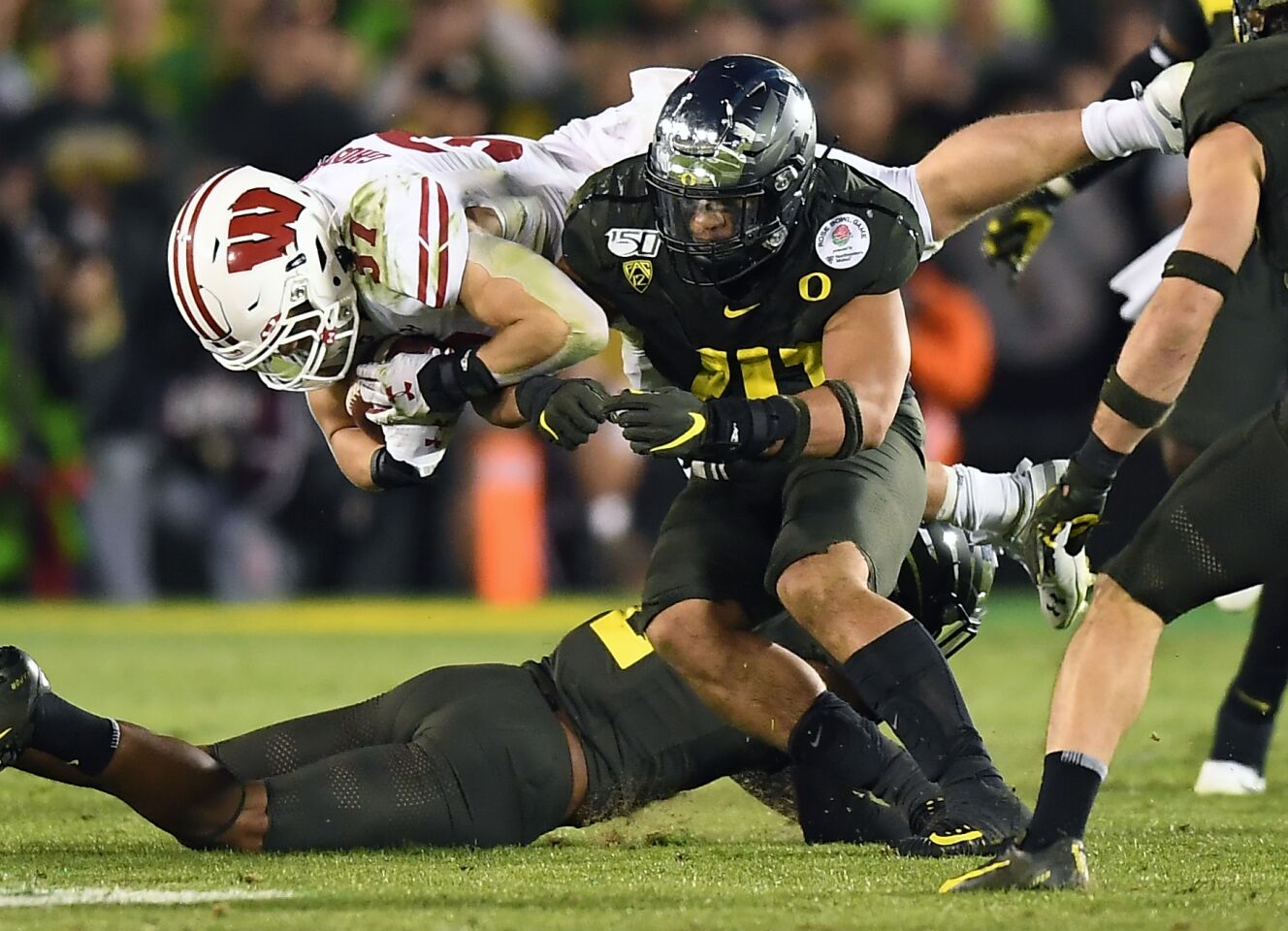 Wisconsin running back Garrett Groshek is upended by the Oregon defense during a fourth-quarter carry.