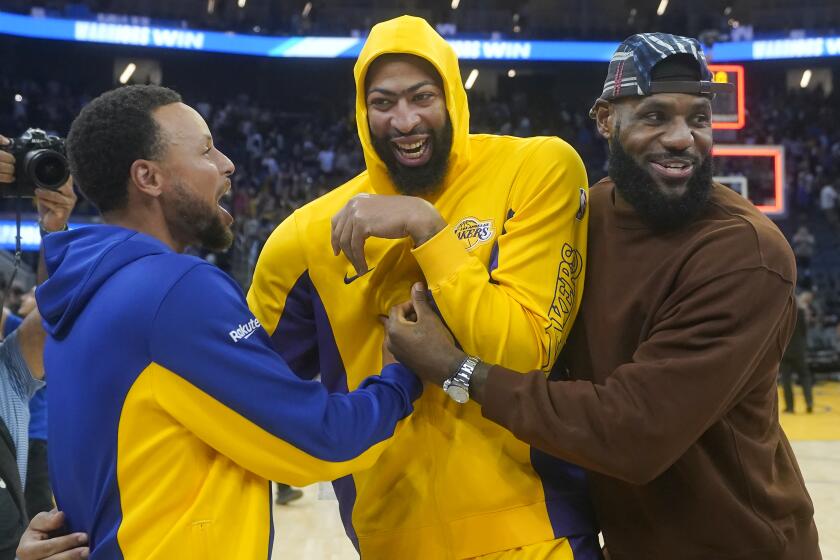 Golden State Warriors' Stephen Curry, left, greets Los Angeles Lakers' Anthony Davis, center, and LeBron James, right, after an NBA preseason basketball game in San Francisco, Saturday, Oct. 7, 2023. (AP Photo/Jeff Chiu)