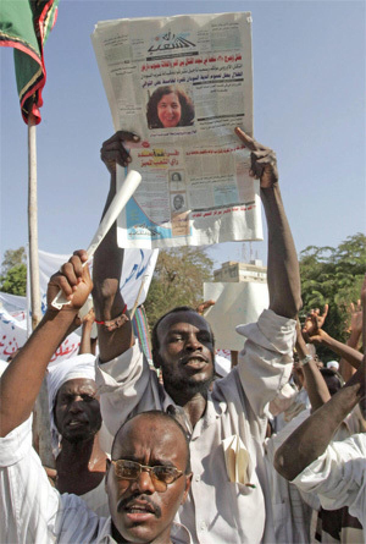 ANGER IN KHARTOUM: A Sudanese demonstrator holds a newspaper with a photo of Briton Gillian Gibbons, who was convicted of insulting Islam. Some wanted her executed.