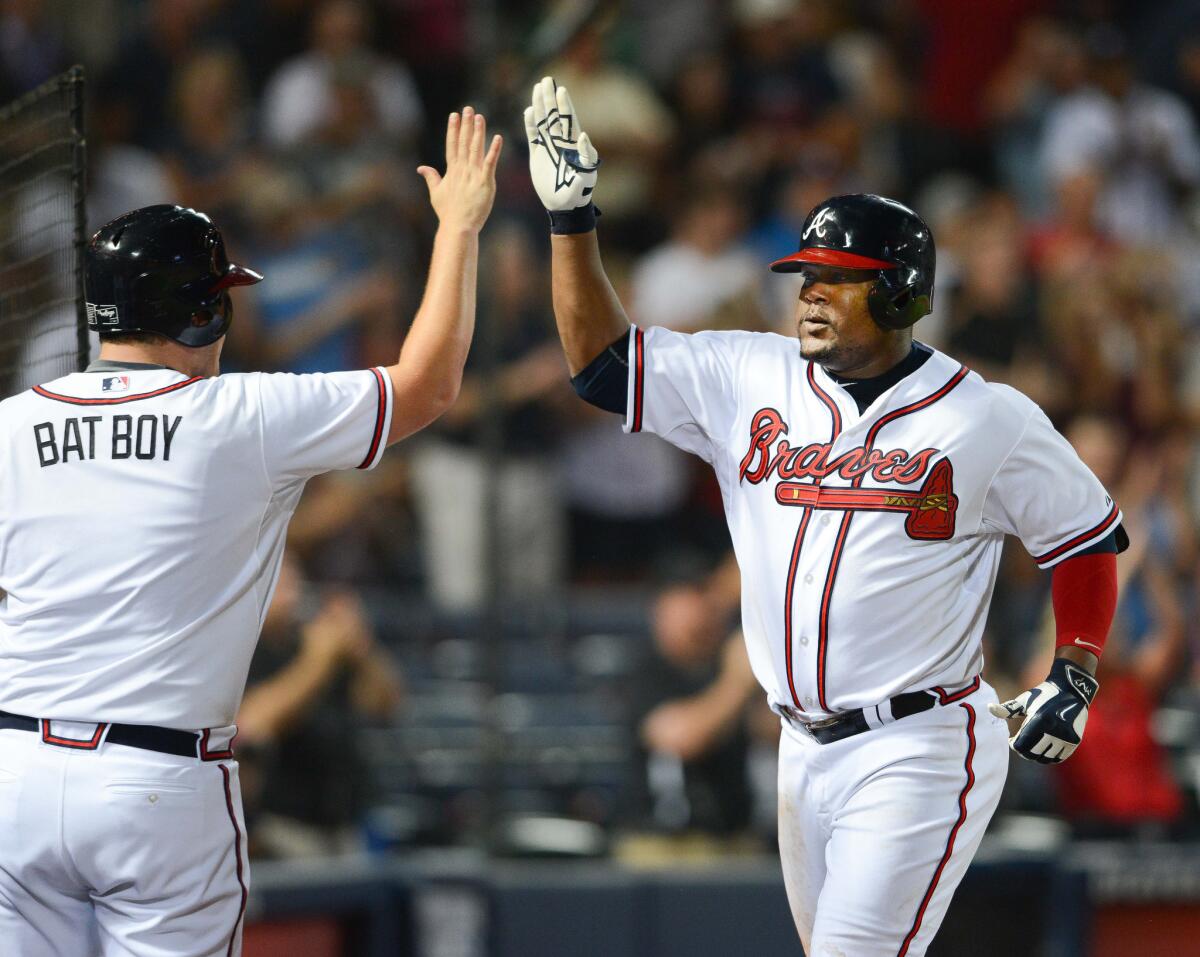 Braves third baseman Juan Uribe high-fives the bat boy after hitting a solo home run against the Phillies on July 3.