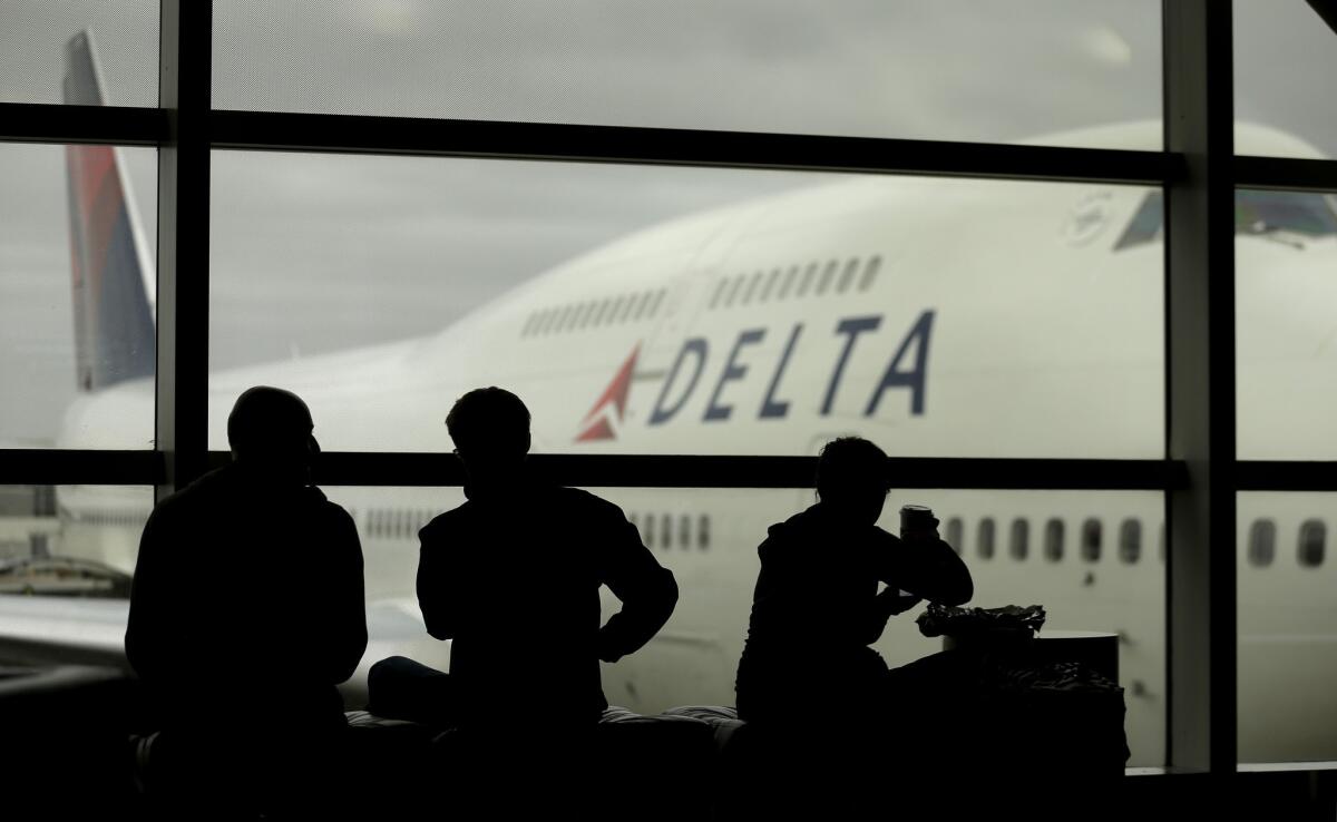 Delta Air Lines passengers wait for flights in Detroit. The airline has requested trademark protection for the slogan "The World's Most Trusted Airline."