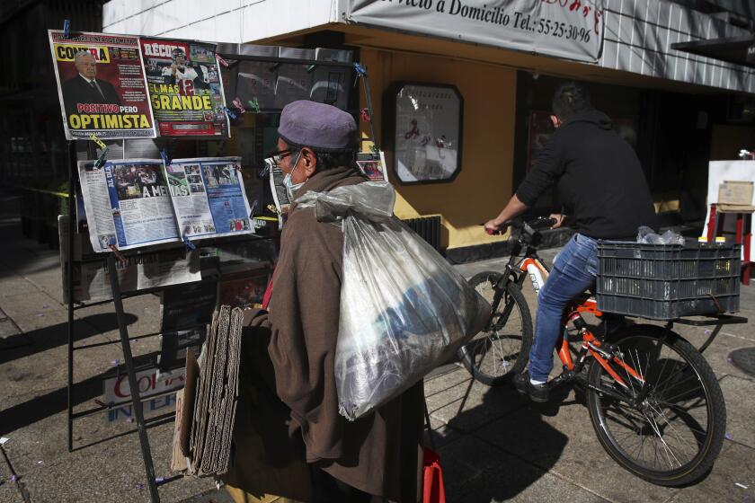 A man reads the front pages of newspapers showing the news that Mexican President Andrés Manuel López Obrador has COVID-19, at a kiosk on Paseo de la Reforma in Mexico City, Monday, Jan. 25, 2021. López Obrador was working from isolation on Monday, Jan. 25, 2021, a day after announcing that he had tested positive for COVID-19, his interior secretary said. (AP Photo/Marco Ugarte)