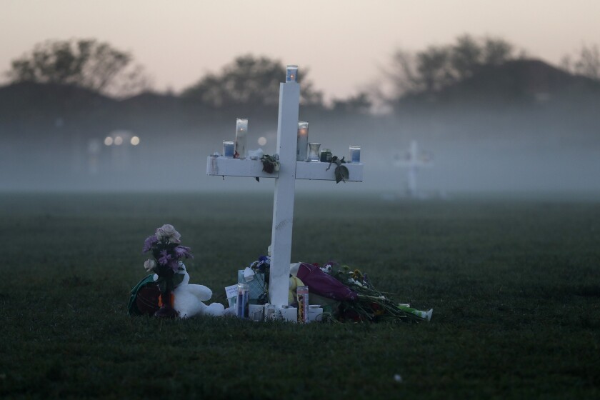 FILE - In this Feb. 17, 2018, file photo, an early morning fog rises where 17 memorial crosses were placed for the 17 students and faculty killed in the shooting at Marjory Stoneman Douglas High School in Parkland, Fla. The 12 jurors and 10 alternates chosen this past week to decide whether Cruz is executed will be exposed to horrific images and emotional testimony, but must deal with any mental anguish alone. (AP Photo/Gerald Herbert, File)