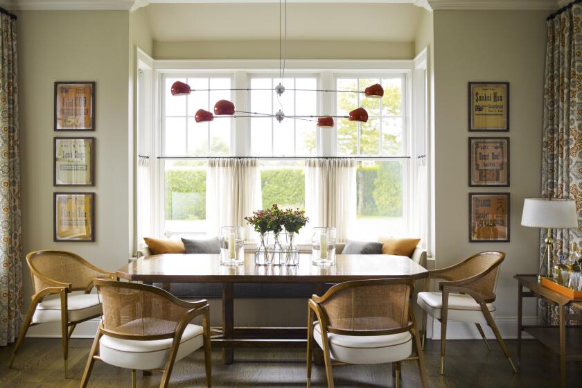 A dining room has framed artwork that includes inexpensive yet eye-catching vintage deli signs.