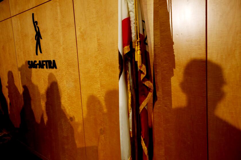 Los Angeles, CA - Screen Actors Guild members cast their shadows on a wall while announcing a strike during a press conference at union headquarters in Los Angeles to announce a strike on Thursday, July 12, 2023. (Luis Sinco / Los Angeles Times)