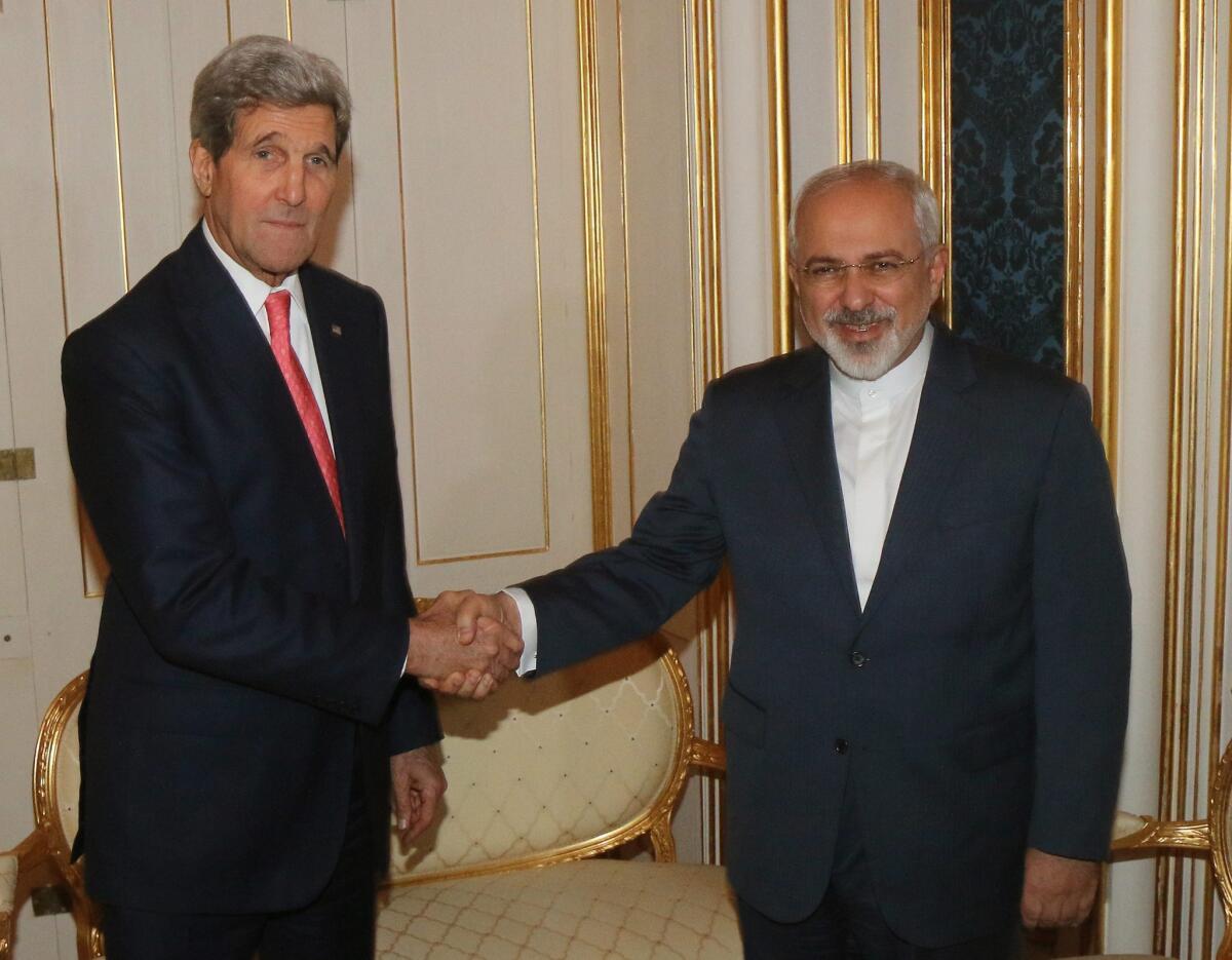 Secretary of State John Kerry, left, and Iranian Foreign Minister Mohammad Javad Zarif shake hands during the talks between the E3+3 in Vienna, Austria.