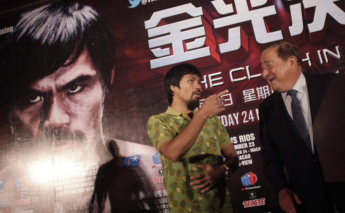 Promoter Bob Arum, right, speaks with boxer Manny Pacquiao before a news conference in Shanghai, China, on July 31. Arum may be in his eighties, but he's still taking risks.