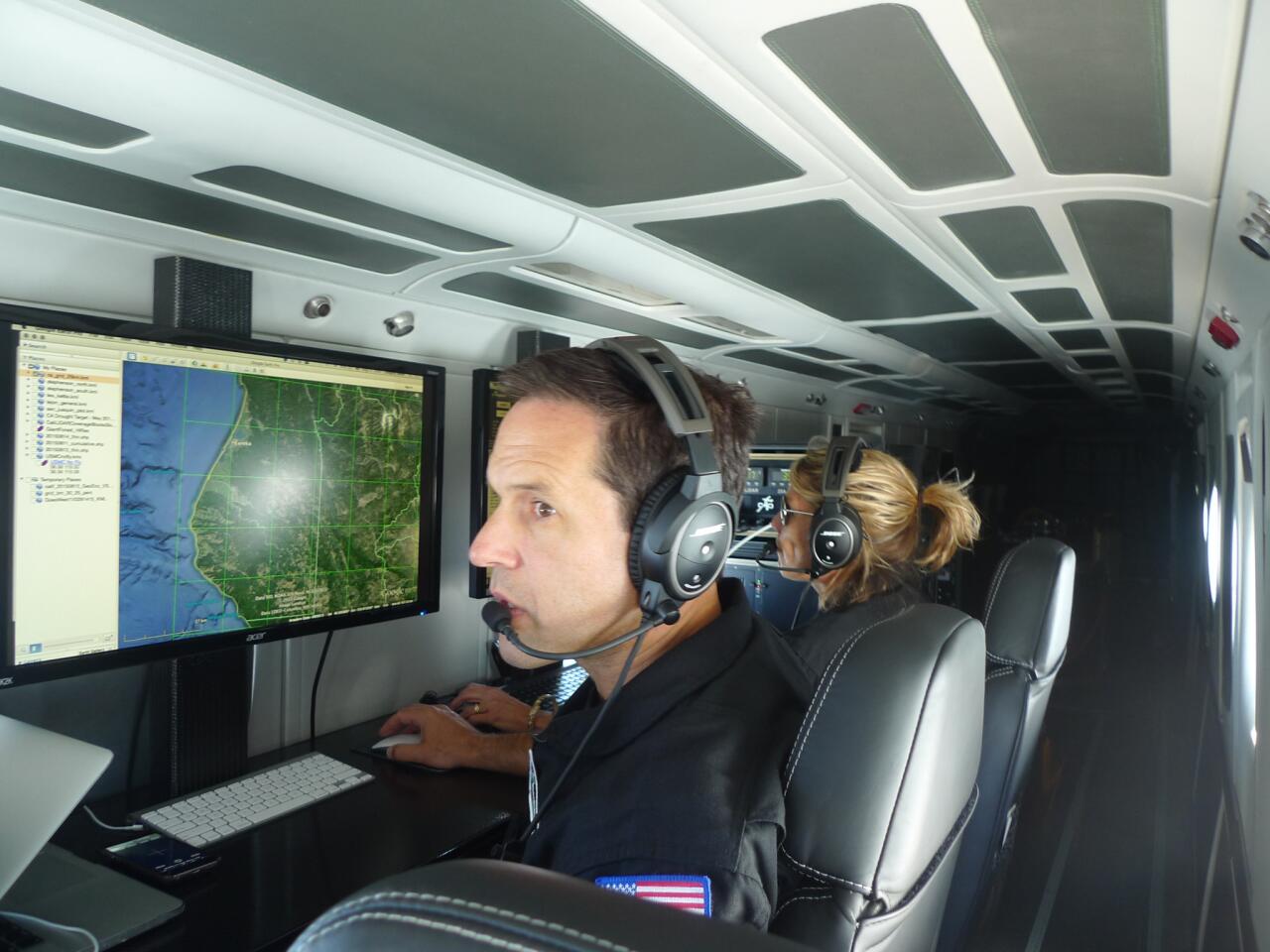 Greg Asner works in his Dornier 228, a twin turboprop. Toggling between a map of the area and a special grid he constructed of the state, Asner sets the aircraft's course as it passes over forest areas.
