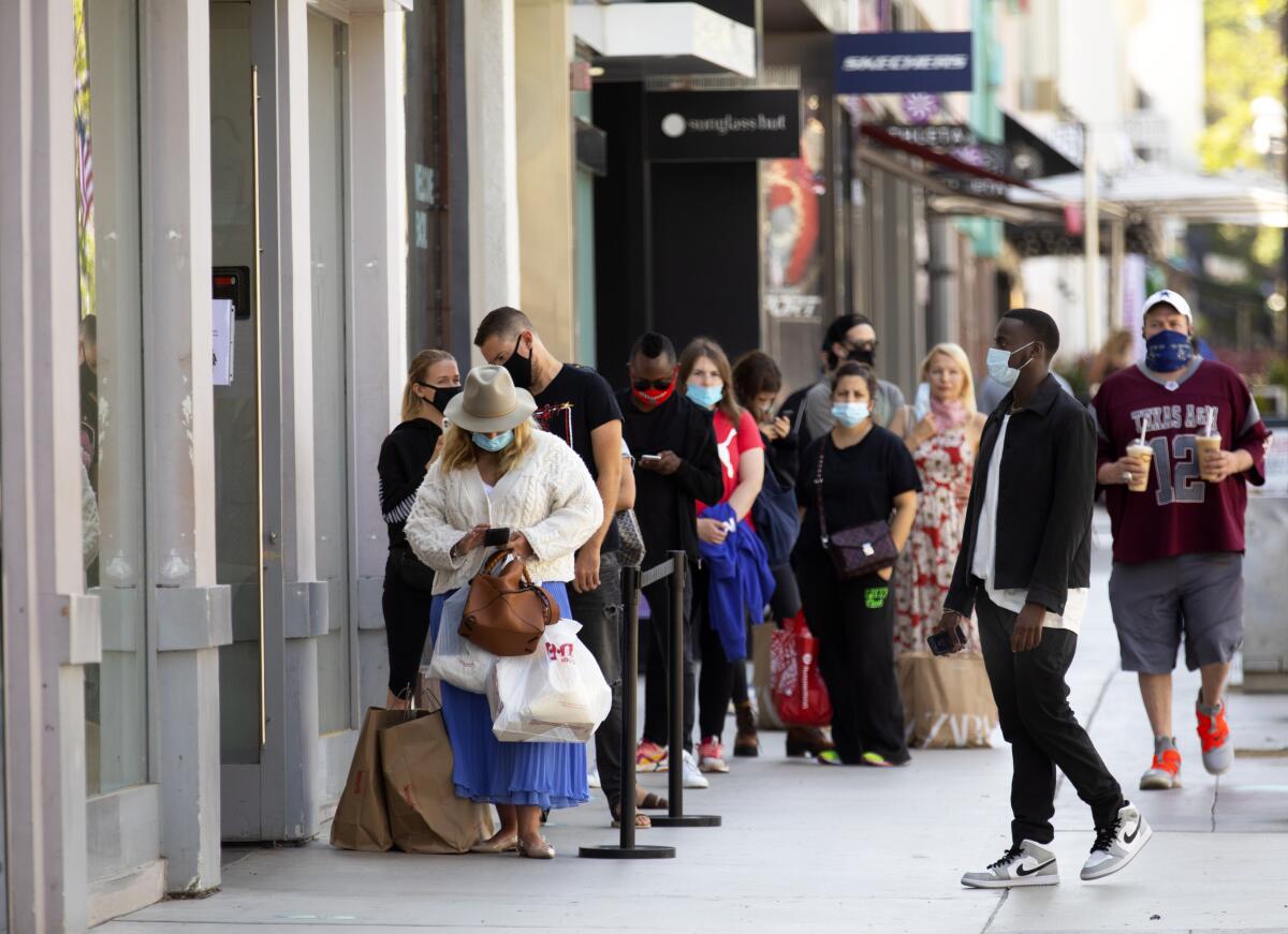 Los clientes usan mascarillas mientras hacen cola para entrar a Zara en 3rd Street Promenade en Santa Mónica.