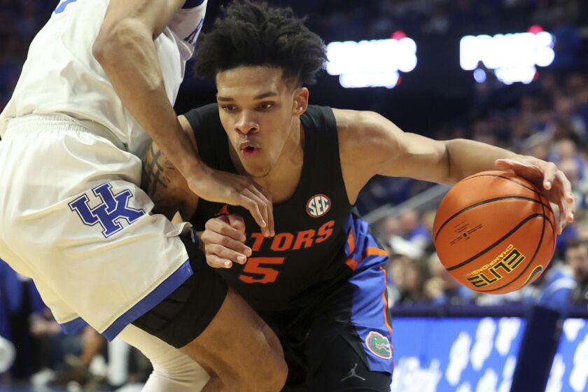 Florida's Will Richard, right, is defended by Kentucky's Jacob Toppin (0) during the second half of an NCAA college basketball game in Lexington, Ky., Saturday, Feb. 4, 2023. (AP Photo/James Crisp)
