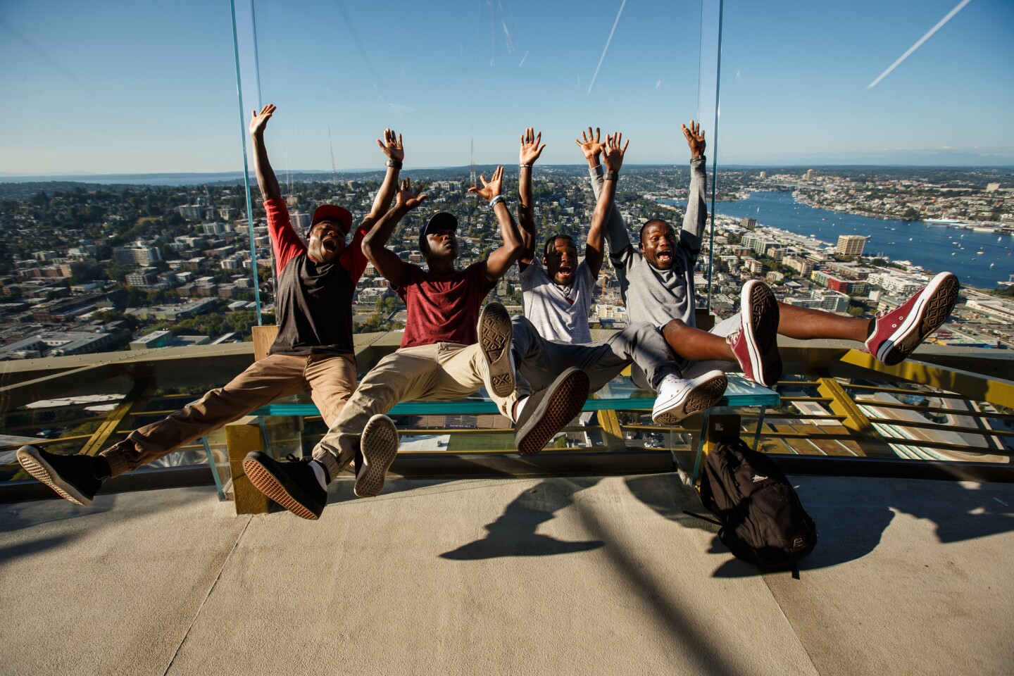 Sandram Mcford, from left, Henry Chisale, Martin Rabson and Jonathan Mvula, all from Malawi, lean back on the glass wall in the newly redesigned glass observation deck in the Space Needle.