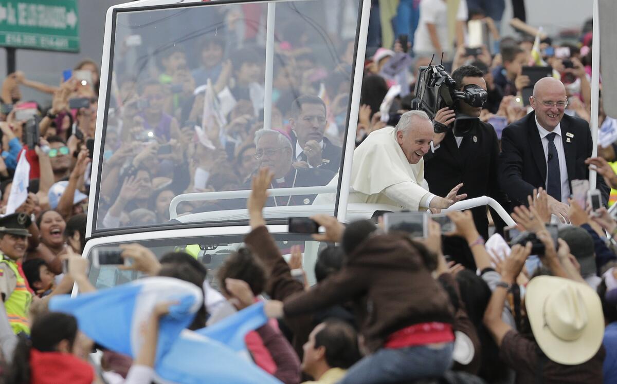 El papa Francisco saluda a un grupo de las decenas de miles de personas que se congregaron a lo largo de la ruta que recorrerá a bordo del Papamóvil en Quito, Ecuador, el domingo 5 de julio de 2015. El papa llegó el domingo a Ecuador en su primera parada de una gira Sudamericana que incluye a Bolivia y Paraguay.