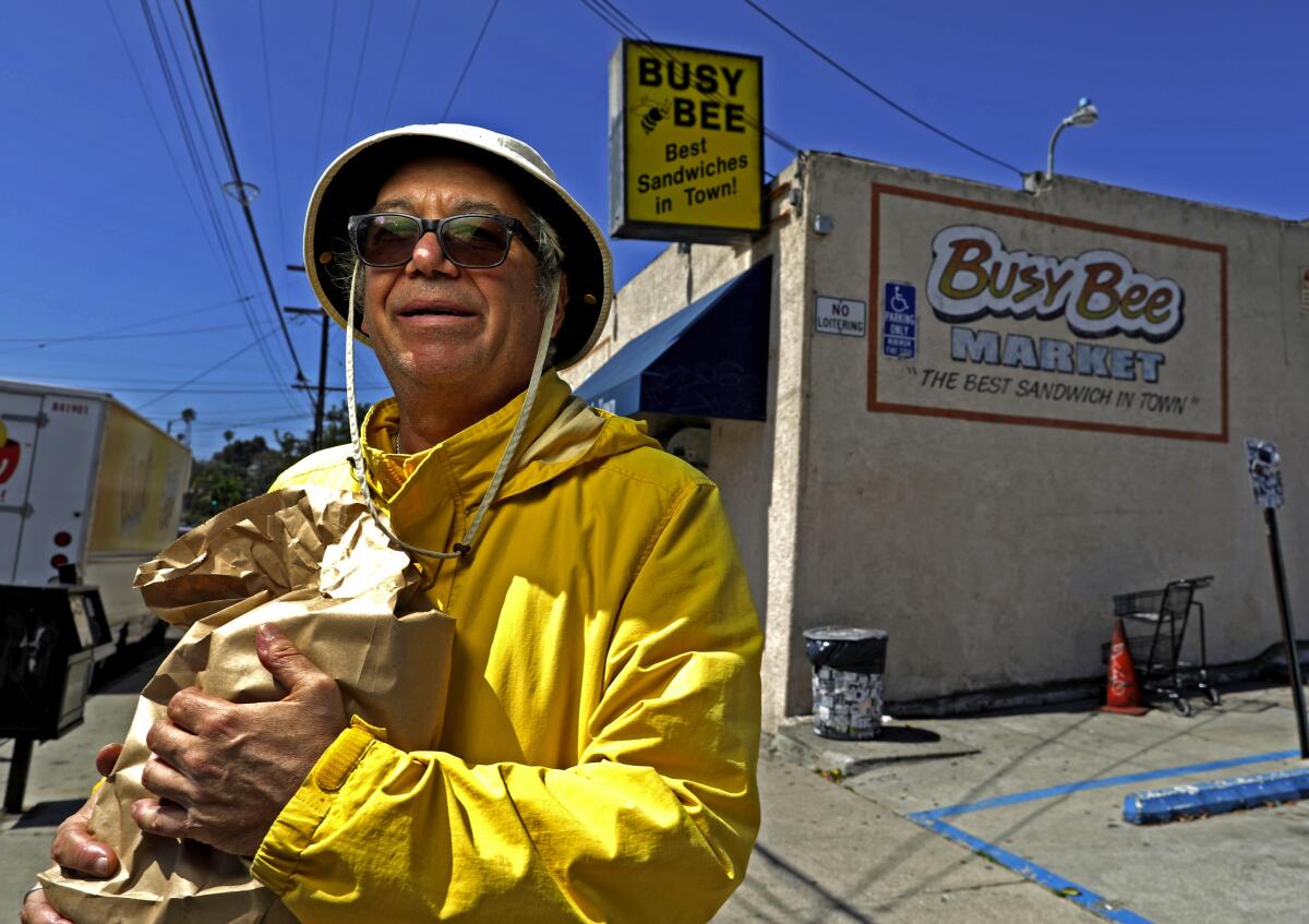 Bassist Mike Watt with a bag of sandwiches outside Busy Bee Market in San Pedro