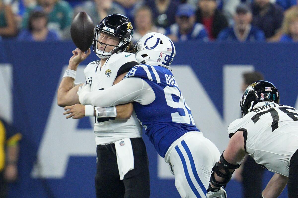  Jaguars quarterback Trevor Lawrence fumbles as he is hit by Colts defensive tackle DeForest Buckner (99).