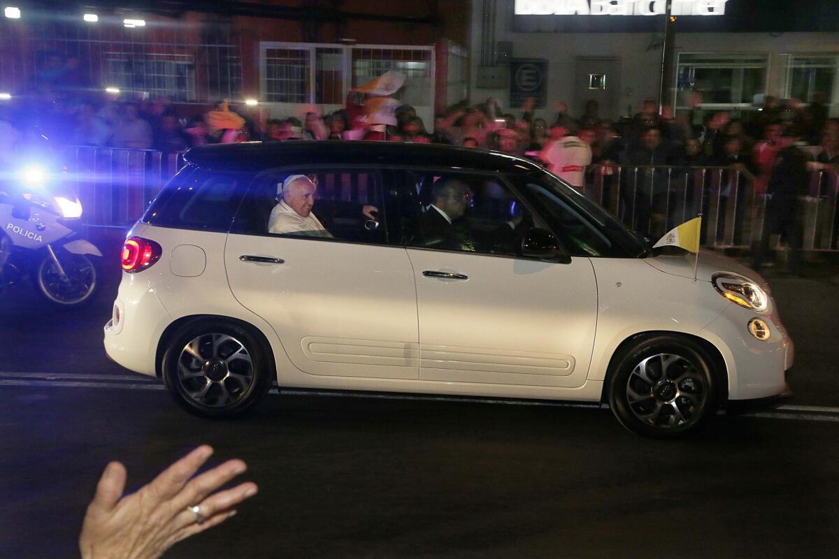 Pope Francis waves from a Fiat on his way to the Vatican's diplomatic mission in Mexico City.