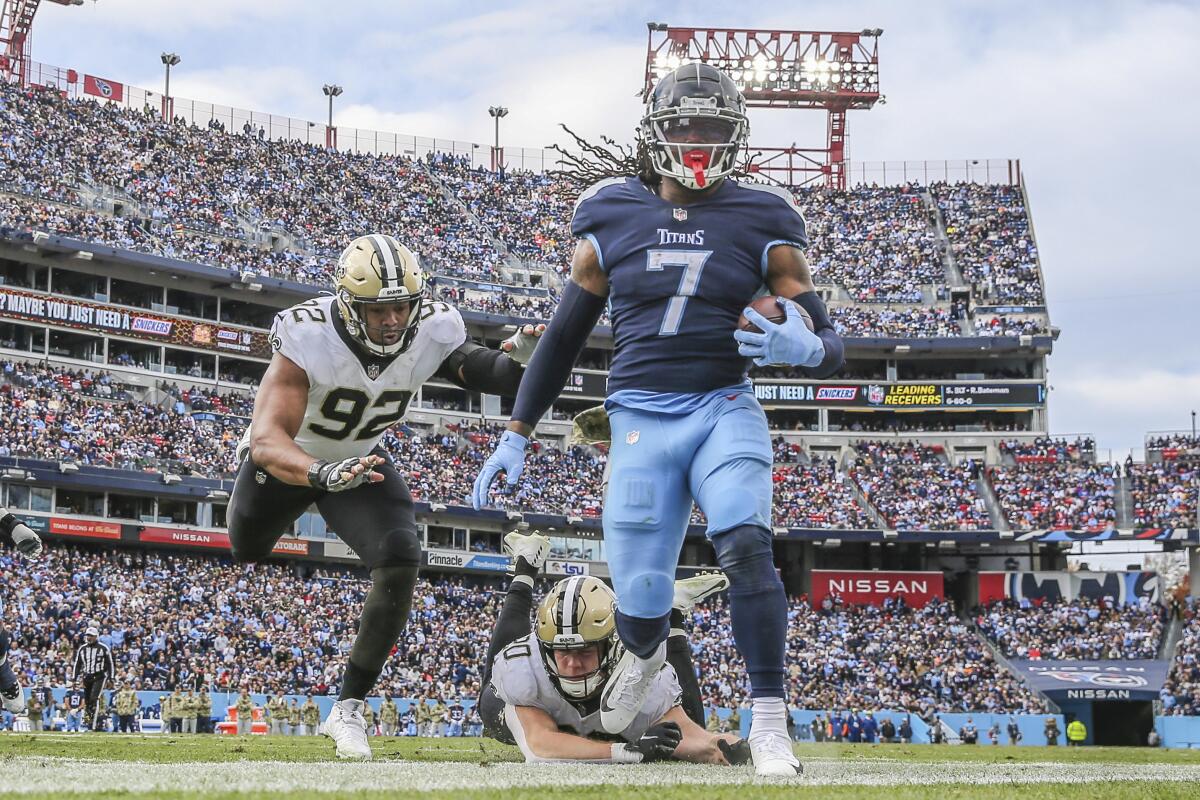 New Orleans Saints' Marcus Davenport and linebacker Pete Werner pursue Tennessee Titans running back D'Onta Foreman.