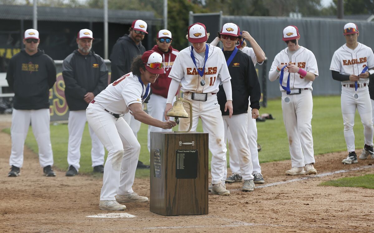 Estancia's James De La O (10) rings the bell with teammate John Uchytil (11) after defeating Costa Mesa.