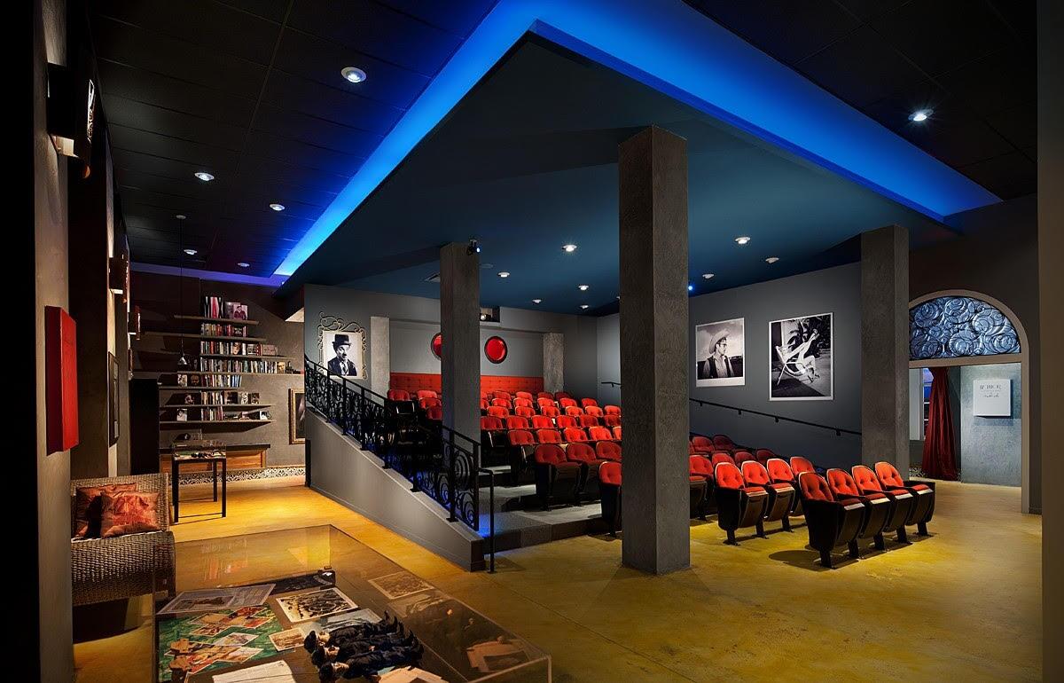 A movie theater with red seats and blue lights.
