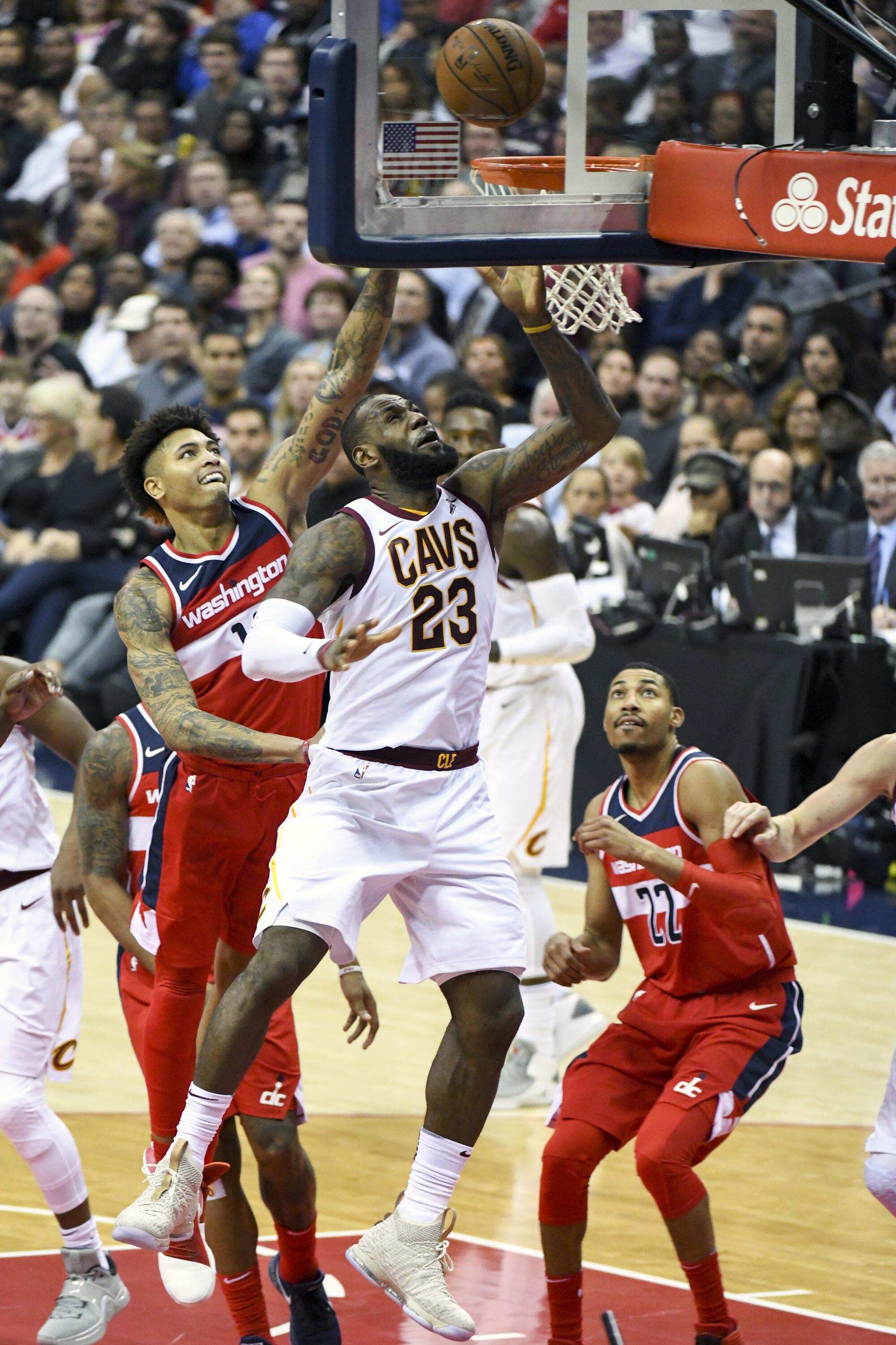 LeBron James scores and is fouled by Wizards forward Kelly Oubre Jr. on a layup.