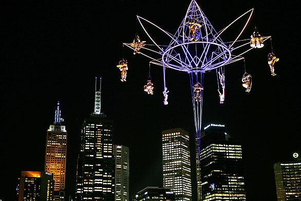 Performers from Transe Express perform during the launch of the Melbourne International Arts Festival on Friday. The performance is held 130 feet in the air and involves an orchestra of bell ringers and percussionists seemingly suspended over the Melbourne city skyline. The carillon contains eight musicians with bells, gongs and drums, and three trapeze artists.