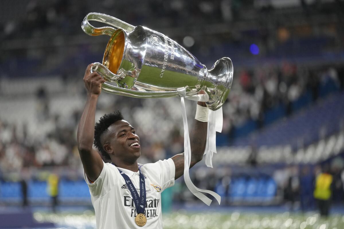 Vinicius Junior hoists the trophy after Real Madrid beat Liverpool 1-0 to win the Champions League soccer final.