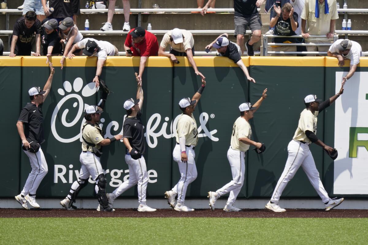 Vanderbilt players celebrate with fans after beating East Carolina in an NCAA college baseball super regional game Saturday, June 12, 2021, in Nashville, Tenn. Vanderbilt won 4-1 to sweep the three-game series and advance to the College World Series. (AP Photo/Mark Humphrey)
