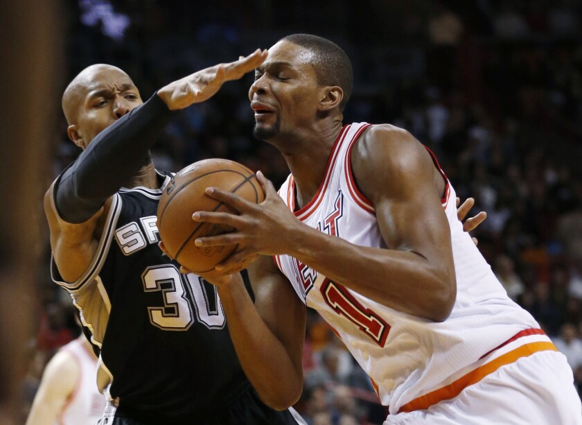 Heat forward Chris Bosh (1) goes up for a shot against Spurs forward David West (30) during the first half of a game on Feb. 9.