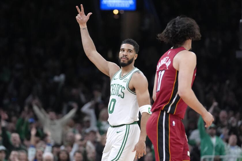 El alero de los Celtics de Boston Jayson Tatum (0) celebra frente al armador mexicano del Heat de Miami Jaime Jaquez Jr. (11), durante la primera mitad del Juego 1 de la serie de primera ronda de postemporada de la NBA, el domingo 21 de abril de 2024, en Boston. (AP Foto/Steven Senne)