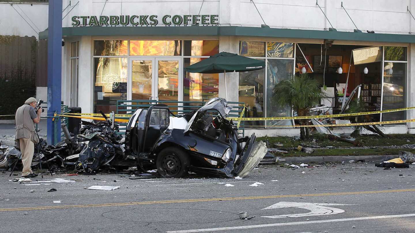 A police photographer documents the scene after a man driving a stolen LAPD cruiser smashed into a Starbucks on La Brea Avenue, officials said.