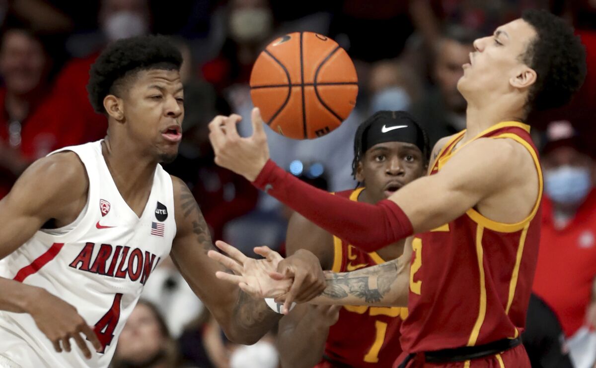 Arizona guard Dalen Terry (4) rips the ball out of the hands of Southern California forward Kobe Johnson (2) in the first half of an NCAA college basketball game in Tucson, Ariz., Saturday, Feb. 5, 2022. (Kelly Presnell/Arizona Daily Star via AP)