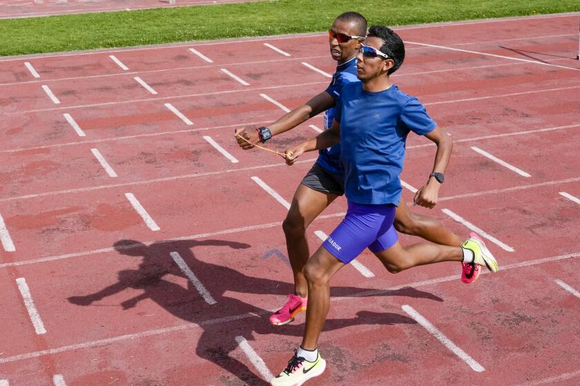 El atleta ecuatoriano Jimmy Caicedo (adelante) y su guía Daniel Taramuel entrenan en Quito el jueves 13 de junio de 2024, con miras a su participación en los Juegos Paralímpicos (AP Foto/Dolores Ochoa)