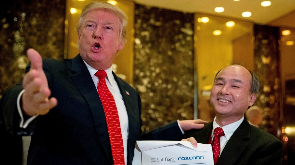 President-elect Donald Trump, accompanied by SoftBank CEO Masayoshi Son, speaks at Trump Tower in New York.