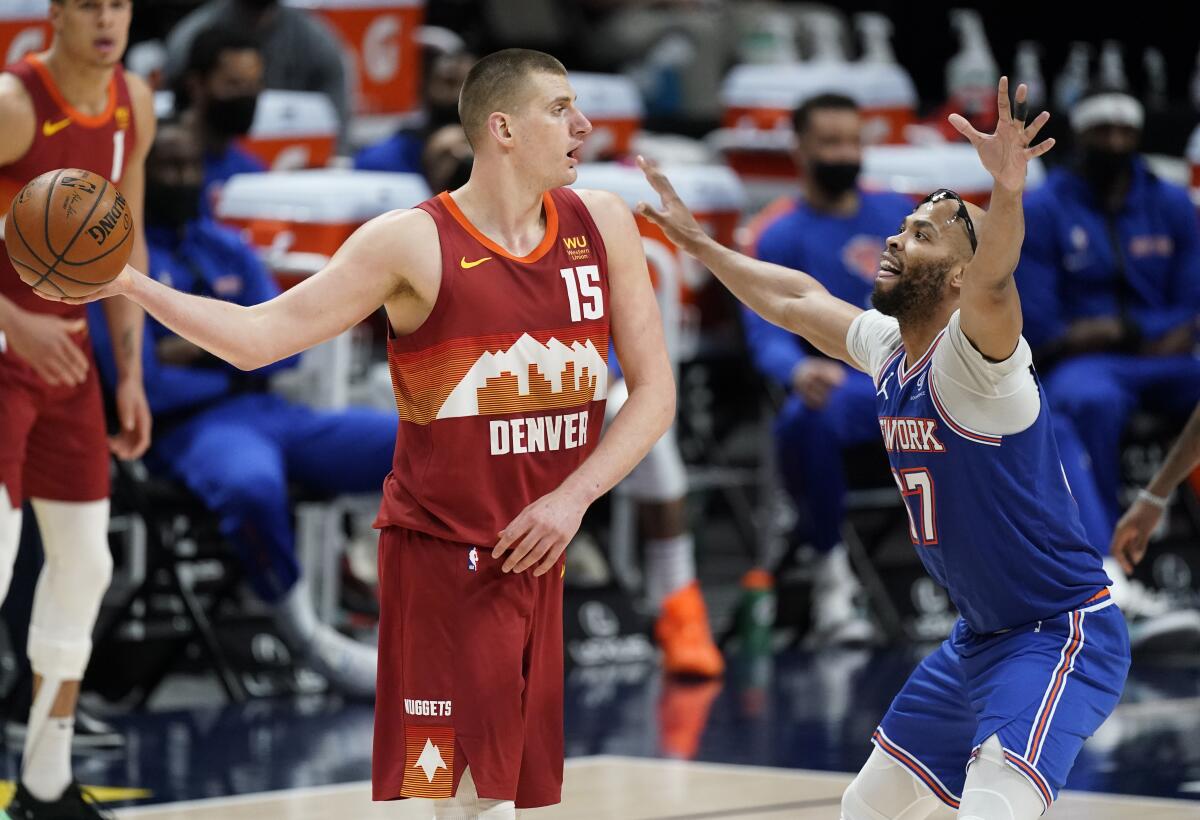 Denver Nuggets center Nikola Jokic (15) looks to pass the ball as New York Knicks center Taj Gibson defends in the second half of an NBA basketball game Wednesday, May 5, 2021, in Denver. (AP Photo/David Zalubowski)