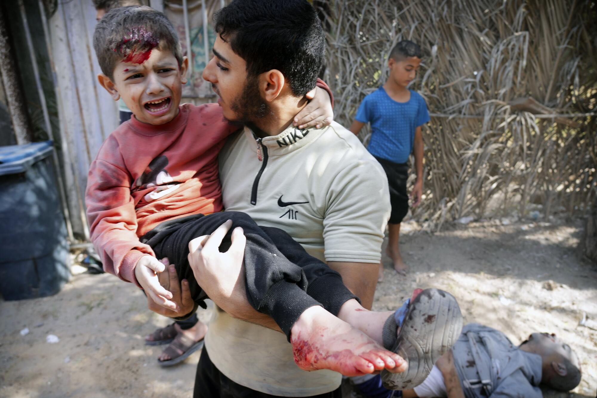 Wounded boy being carried after an Israeli strike in Gaza