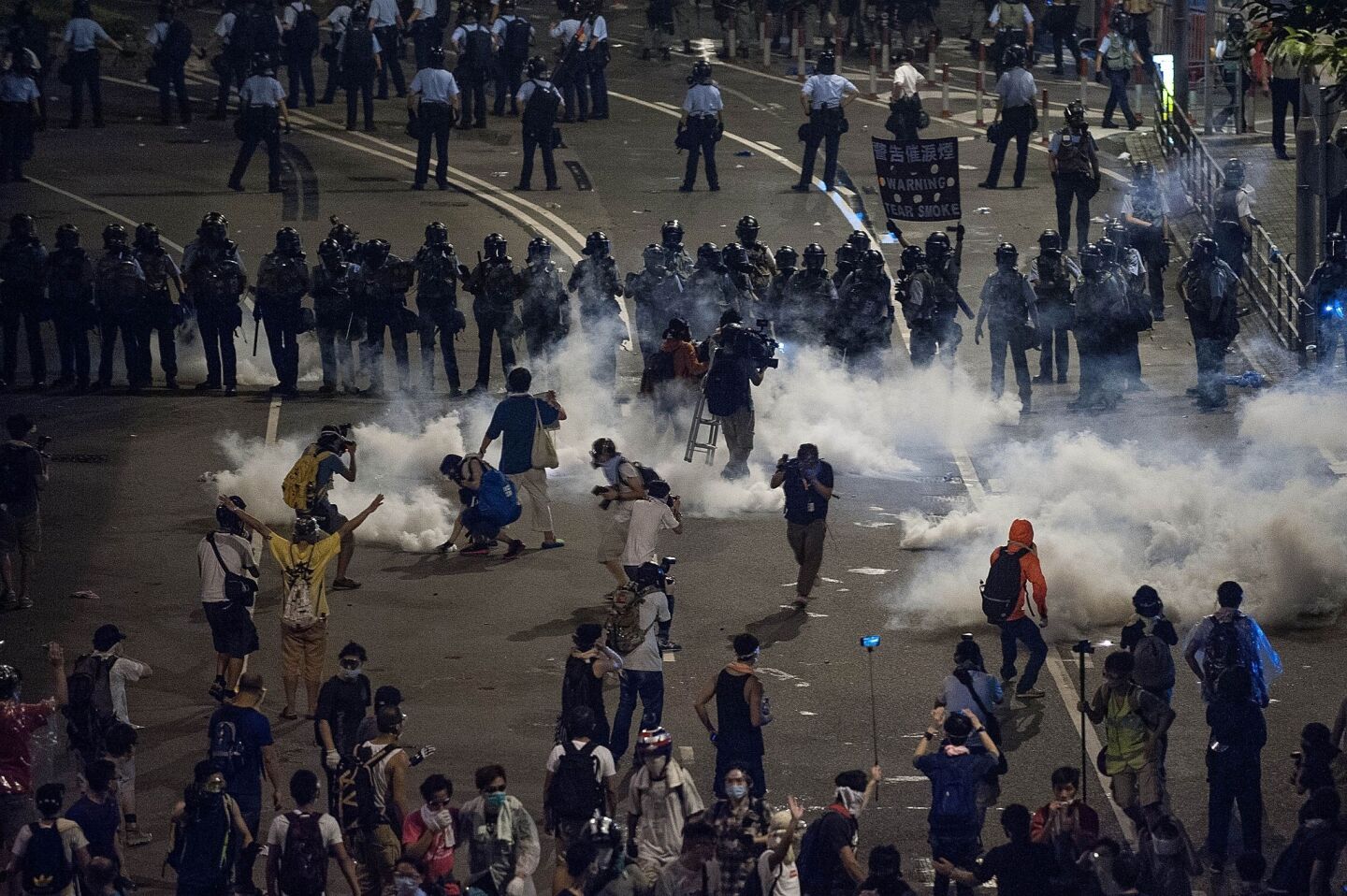 Demonstrators disperse as tear gas is fired by police on Sept. 29, 2014.