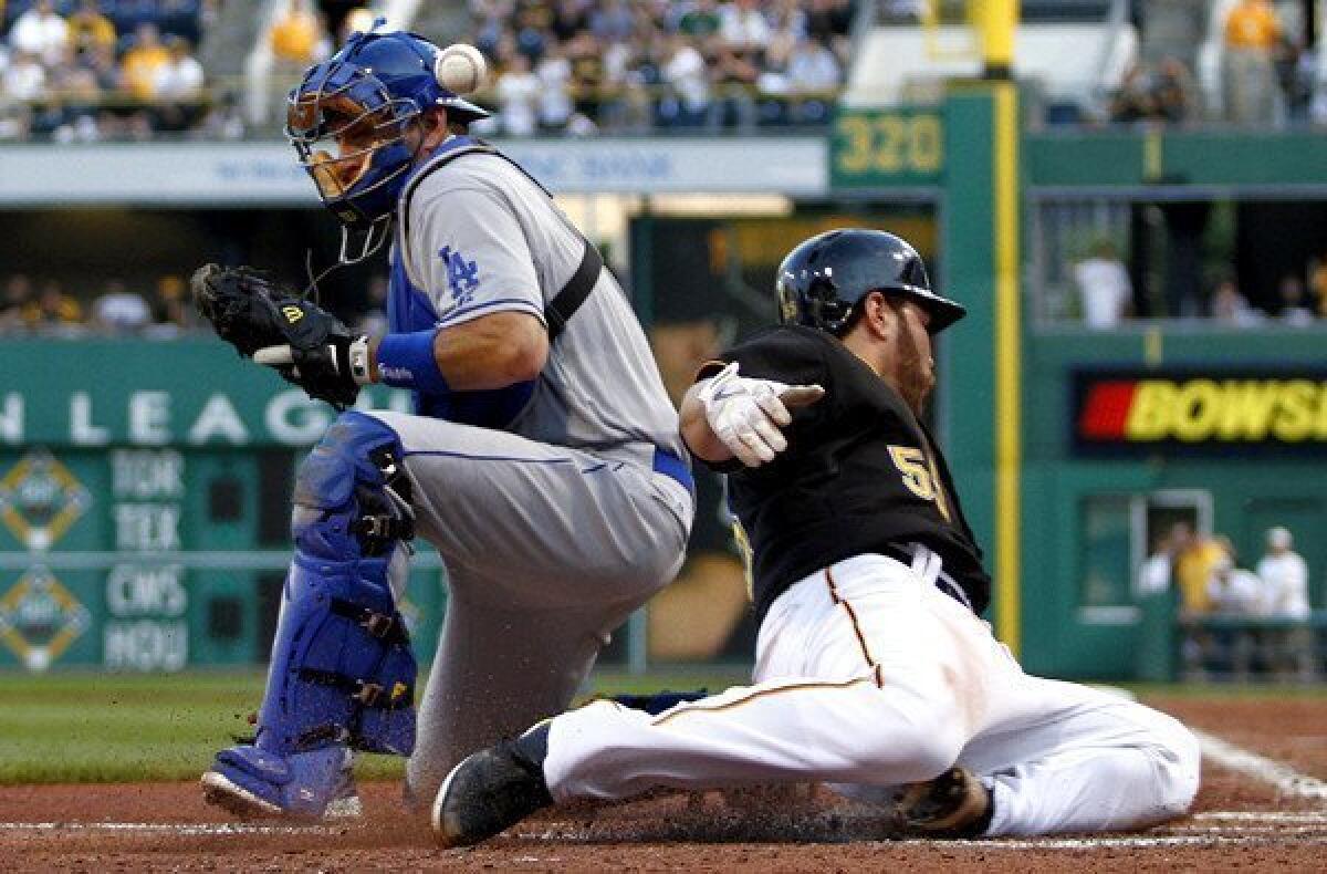 Pirates catcher Russell Martin beats the throw to Dodgers catcher A.J. Ellis in the third inning Friday night.
